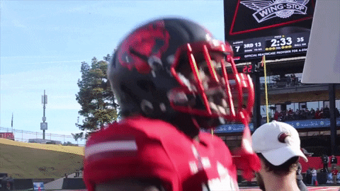 Football Player in Front of Scoreboard Saying Wing Stop