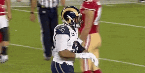 Football Player in Helmet Holding Football