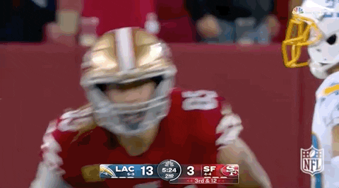 Football Player in Helmet in Front of Scoreboard