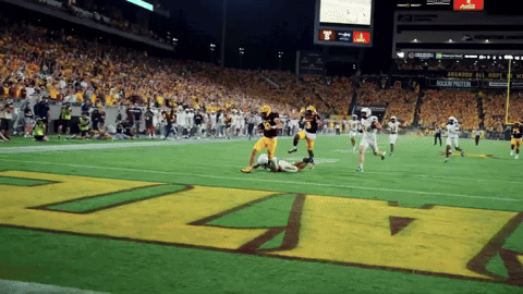 Football Player in Maroon Jersey Number 10 Throwing Ball