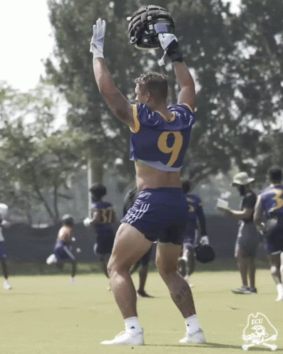 Football Player in Number 9 Jersey Holding Helmet