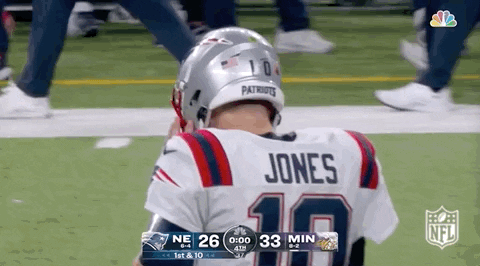 Football Player in Patriots Jersey Kneeling on Field