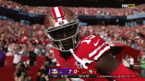 Football Player in Red and White Helmet in Front of Crowd