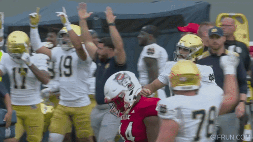 Football Player In Red Jersey Number 4 Surrounded By Other Players GIF
