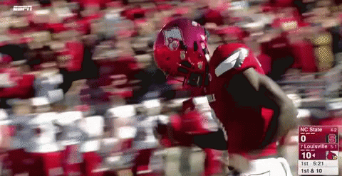 Football Player in Red Uniform Running With Scoreboard
