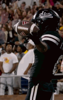 Football Player in State Helmet Holding Football