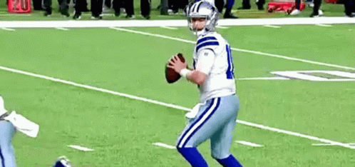Football Player in White and Blue Uniform Holding Football