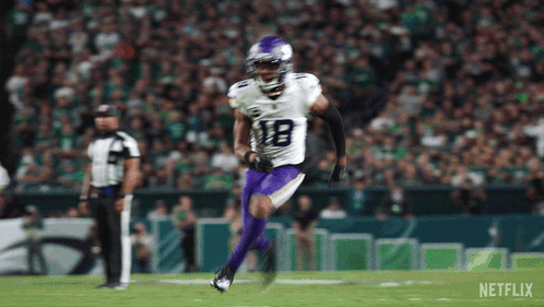 Football Player in White Jersey and Purple Pants Running