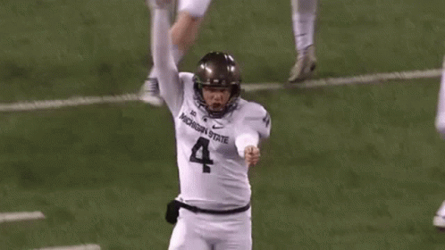 Football Player in White Jersey Number 4 Kicking Ball
