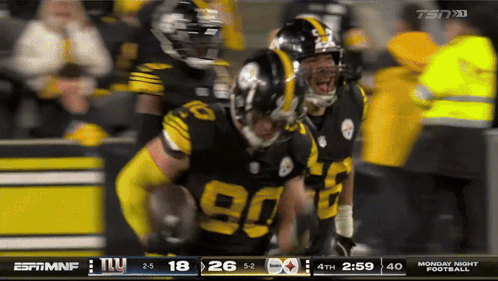Football Player in Yellow Helmet in Front of Scoreboard