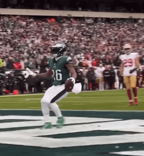 Football Player Jumping Holding Ball On Field GIF