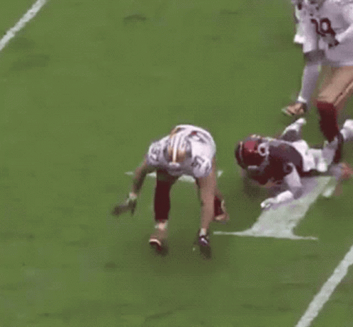 Football Player Kneeling During Tackle