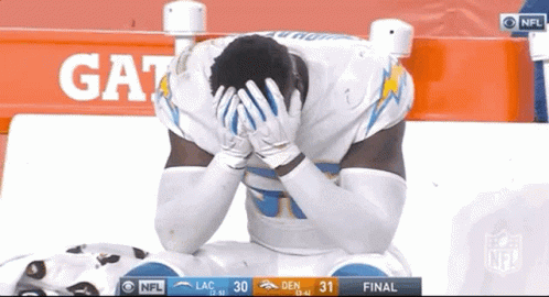 Football Player Kneeling Hands On Head In Front Of Gatorade Sign GIF