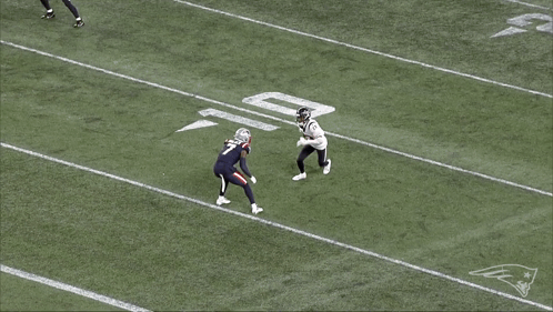 Football Player Laying on Field With Patriots Logo