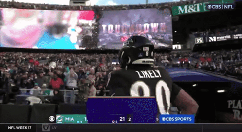 Football Player Likely Standing Before Large Screen