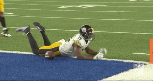 Football Player Lying On Field With Ball GIF