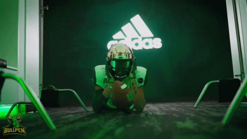 Football Player Lying on Floor in Front of Adidas Sign