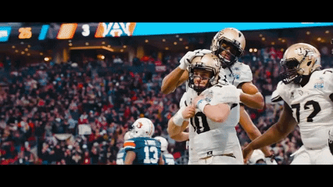 Football Player Number 10 Hugged by Teammates