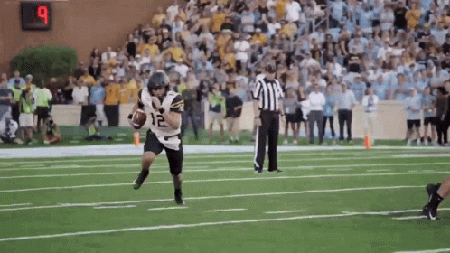 Football Player Number 12 Running With Ball