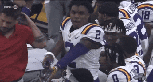 Football Player Number 2 Surrounded By Teammates GIF