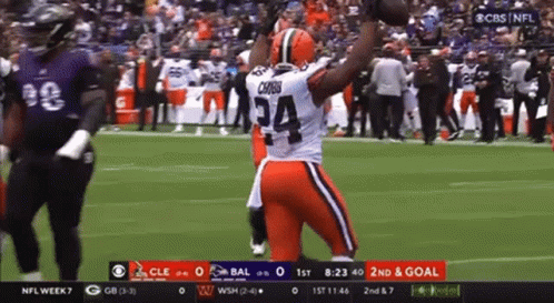 Football Player Number 34 Holding Football in Air