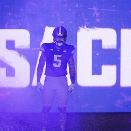Football Player Number 5 Standing in Front of Large Screen