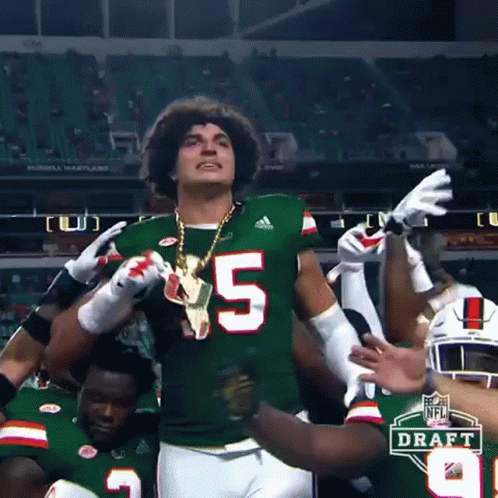 Football Player Number 5 Surrounded by Teammates
