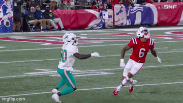 Football Player Number 6 Running Toward Another Player