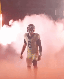 Football Player Number 6 Walking Through Smoke