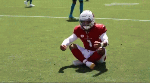 Football Player Number 7 Sitting on Grass