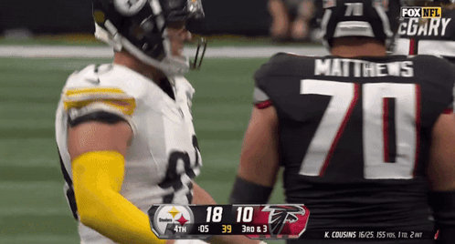 Football Player Number 70 Jersey Talking to Another Player