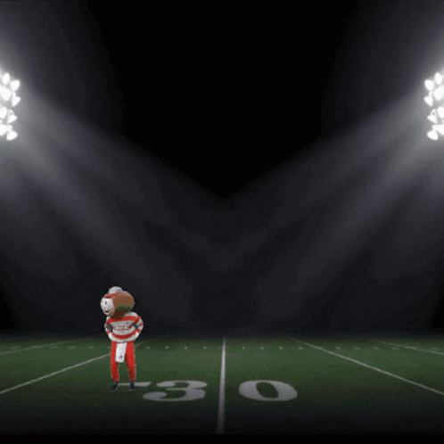 Football Player on Field With It's Game Time Scoreboard