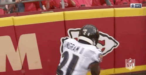 Football Player Running In Front Of NFL Logo Wall GIF