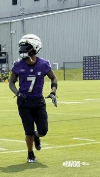 Football Player Running in Purple Jersey and Helmet