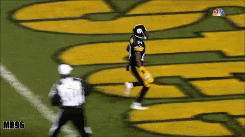 Football Player Running Near Mr96 Sign