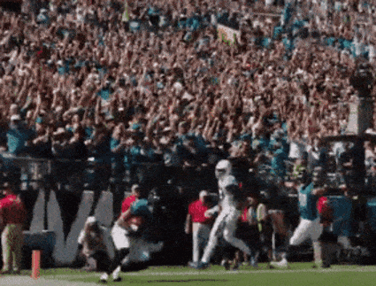 Football Player Running On Field In Front Of Crowd GIF