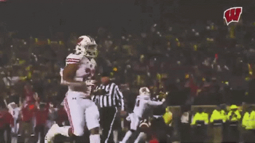 Football Player Running With W Logo in Background