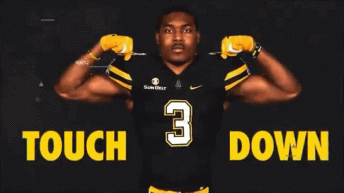 Football Player Standing in Front of Tough Down Sign