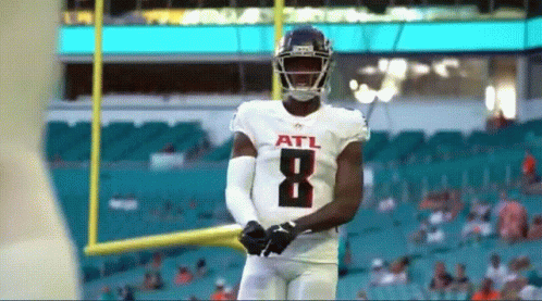 Football Player Throws Ball On Field With Crowd GIF
