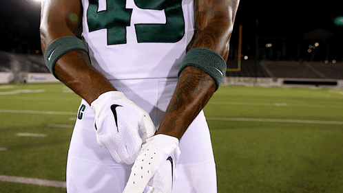 Football Player With H Helmet In Front Of Two Bobcats Logos GIF