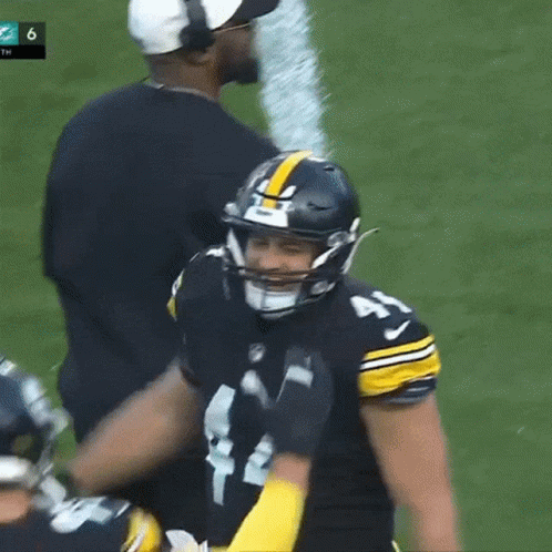 Football Player With Helmet and Coach Behind