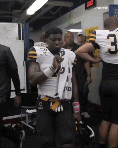 Football Player With Jersey Number 3 In Locker Room