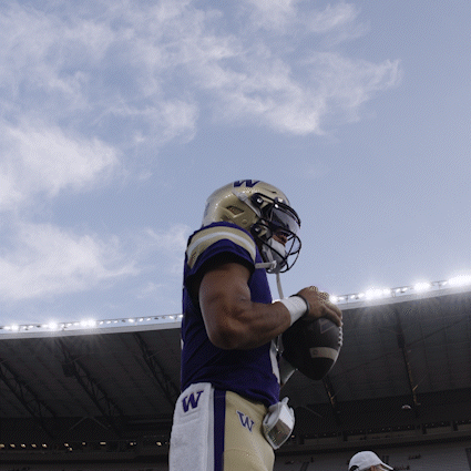 Football Player With W on Shorts Holding Ball