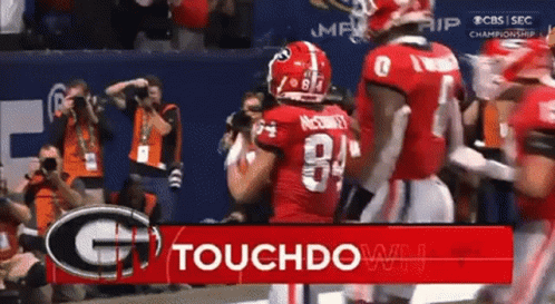 Football Players at Touchdown Sign