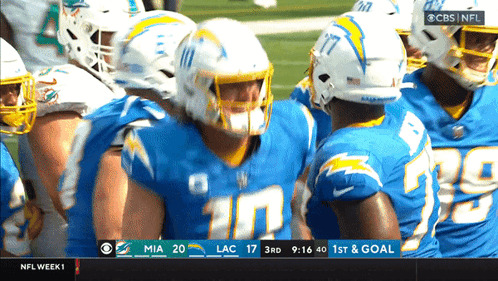 Football Players Huddled On Field GIF