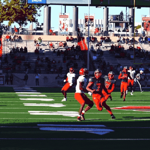 Football Players on Field With Pepsi Sign