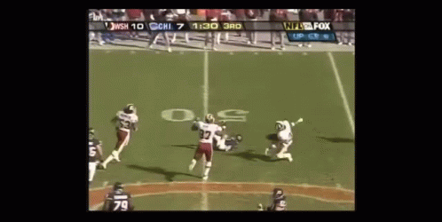 Football Players on Field With Referee and NFL Scoreboard