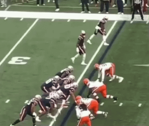 Football Players on Field With Sideline Letter E