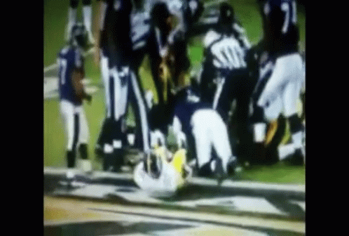 Football Players Playing One Lying on Ground