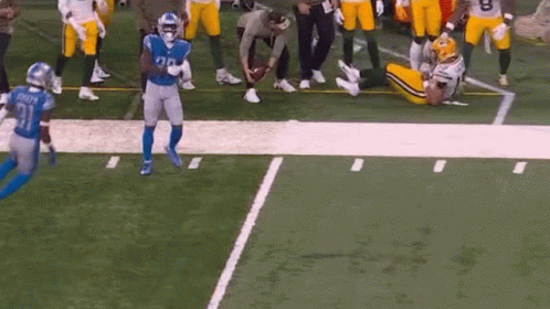 Football Players Playing, One Lying